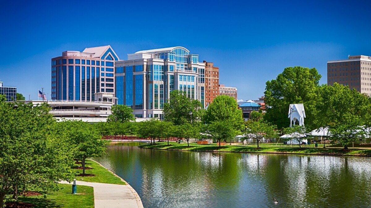 A body of water with trees and buildings around it Description automatically generated with medium confidence